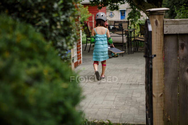 Little girl in a red dress with a bag in the park — Stock Photo