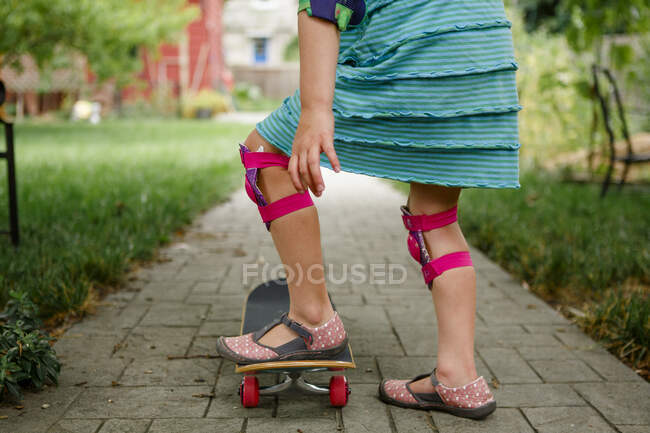 Young woman with skateboard on street — Stock Photo