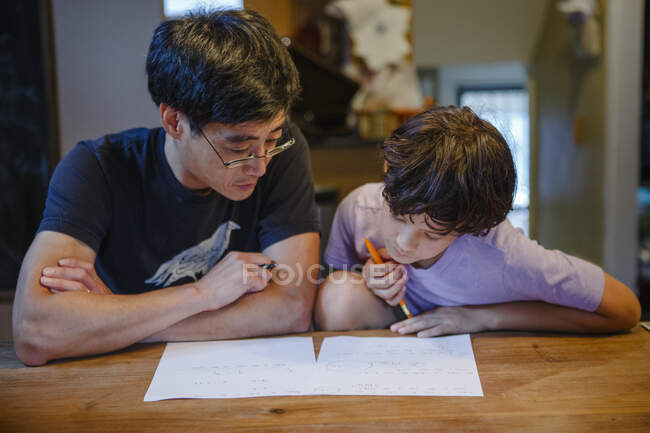 Padre e hijo leyendo libro en casa - foto de stock