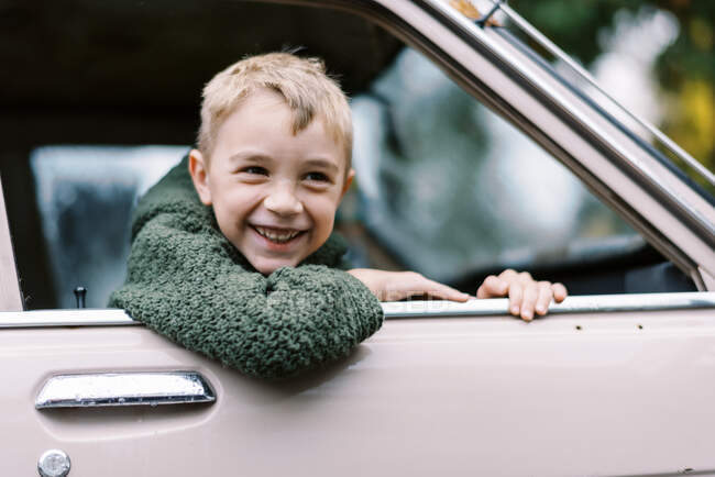 Маленький мальчик с машиной в окне — стоковое фото