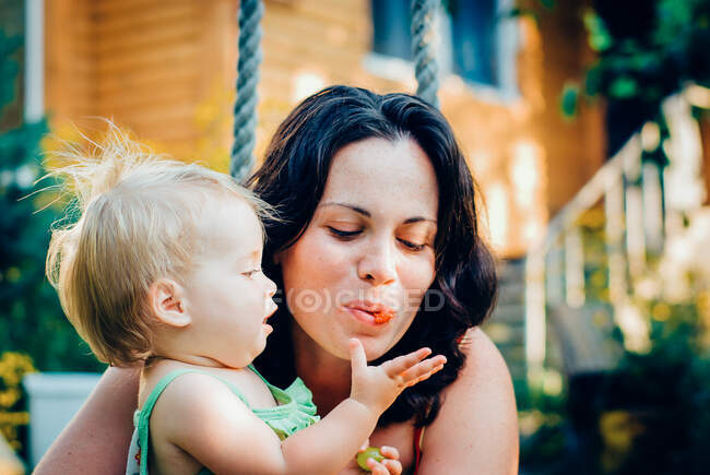 Menina mãe alimentando com bagas — Fotografia de Stock