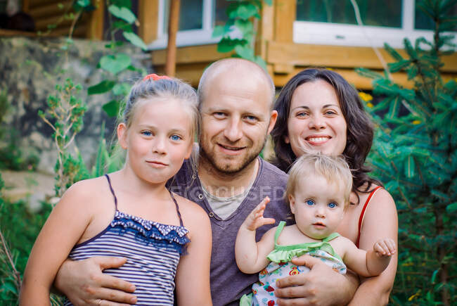 Portrait of happy family against house — Stock Photo