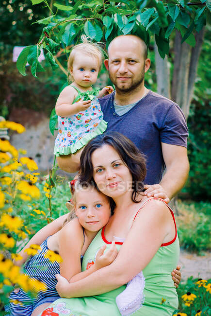 Porträt einer glücklichen Familie im heimischen Garten — Stockfoto