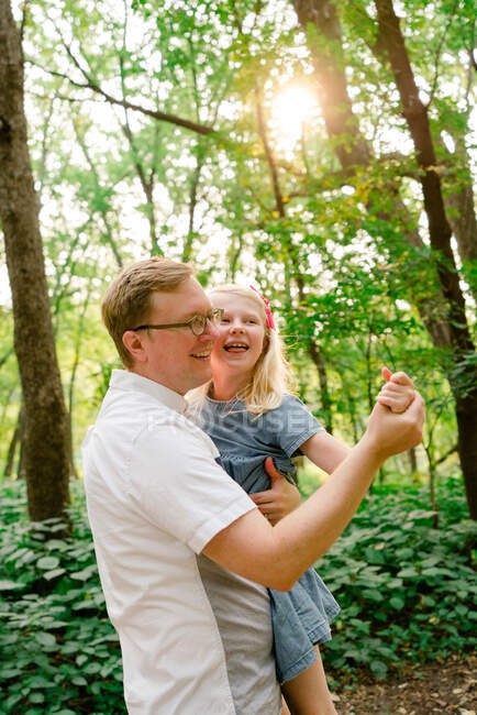 Portrait of a father and daughter dancing together in the forest — Stock Photo