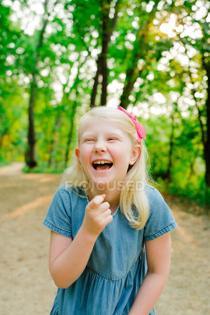 Tiro cortado de uma jovem garota rindo no meio de uma trilha — Fotografia de Stock