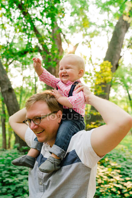 Retrato de primer plano de un niño sobre los hombros de su padre - foto de stock