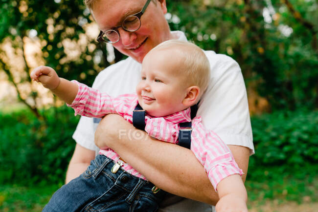 Retrato recortado de un padre sosteniendo a su bebé - foto de stock