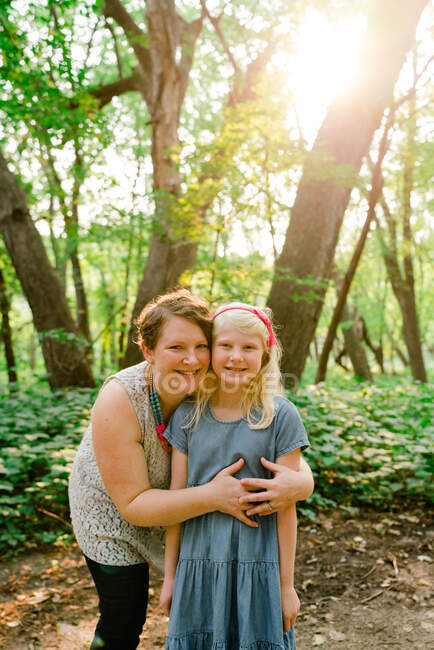 Retrato directo de una madre y una hija juntas en el bosque - foto de stock