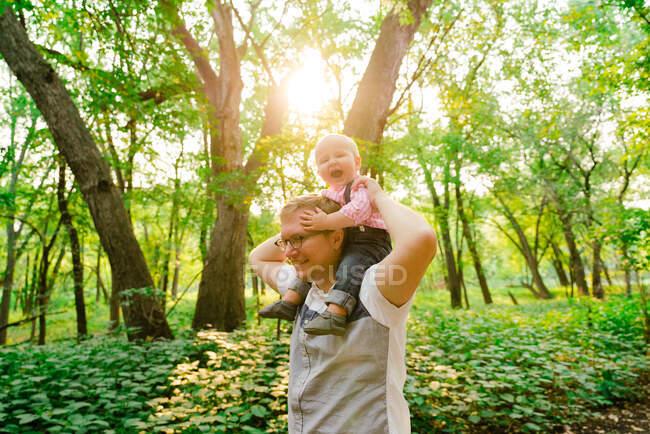 Lifestyle portrait of a baby riding on his dad's shoulders — Stock Photo