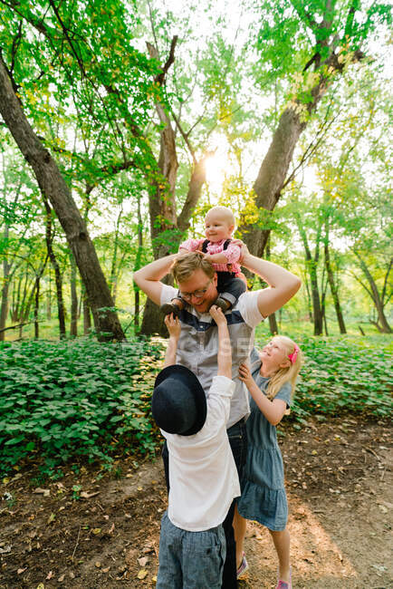 Lifestyle portrait of a father and three children — Stock Photo