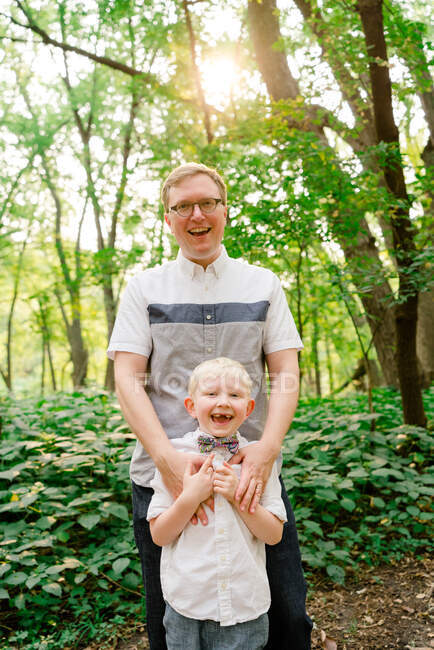 Straight on view of a father and son together in the forest — Stock Photo