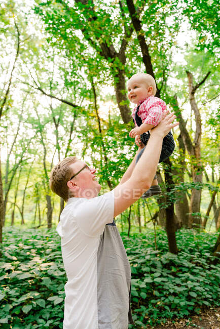 Крупним планом вид батька, який піднімає дитину в повітрі — стокове фото