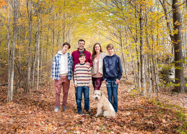 Portrait of family of five outside in wooded area on autumn day. — Stock Photo