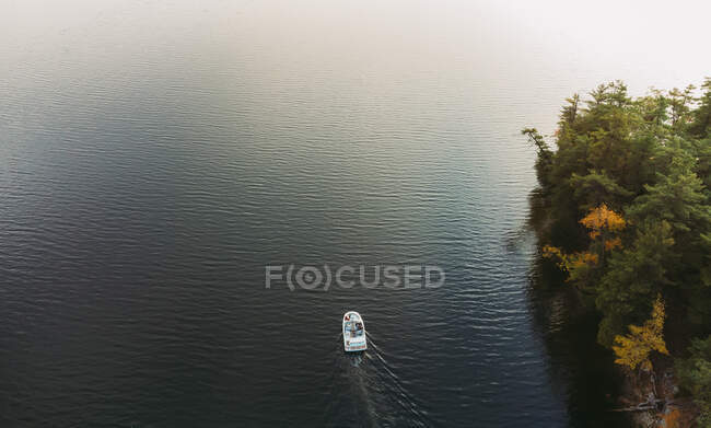 Вид с воздуха на лодку на темной воде озера в Онтарио, Канада. — стоковое фото