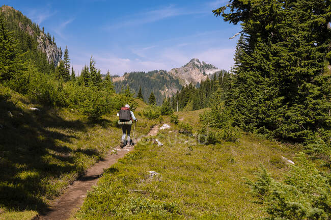 Zaino in spalla femminile attraverso le cascate su un sentiero escursionistico — Foto stock