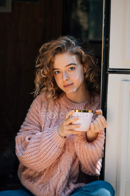 Jovem mulher bebendo café na porta do reboque. — Fotografia de Stock