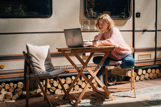 Исследование женщины с ноутбуком возле трейлера на открытом воздухе. — стоковое фото