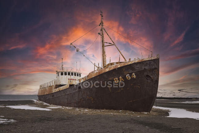 Viejo barco varado en la playa nórdica en invierno - foto de stock