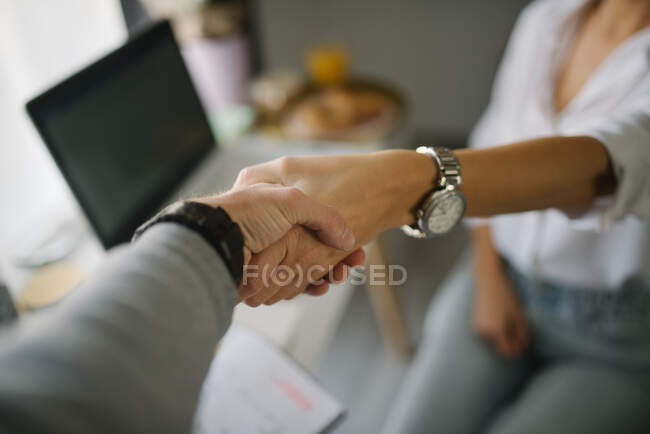 Close-up of a woman shaking hands with a man. — Stock Photo