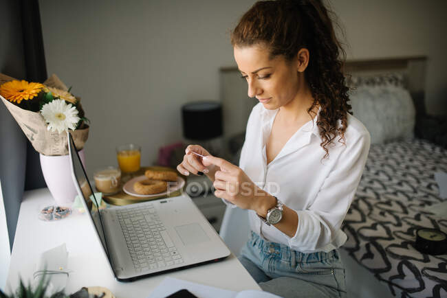 Женщина сидит за рабочим столом и смотрит на открытку — стоковое фото