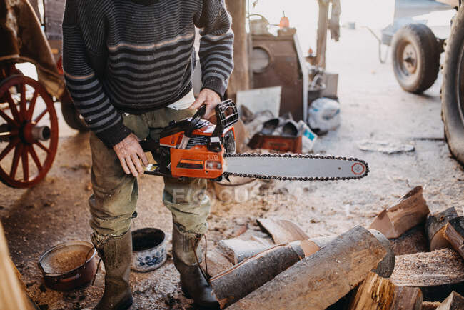 Close-up of a man holding a chainsaw. — Stock Photo