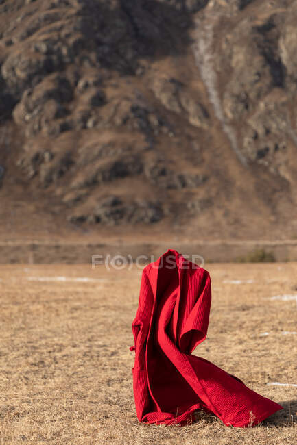 Accappatoio rosso volante sullo sfondo delle montagne — Foto stock