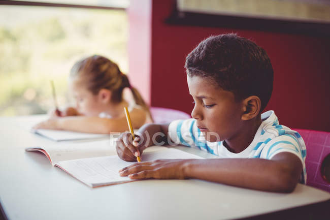 Schüler machen Hausaufgaben im Klassenzimmer — Stockfoto