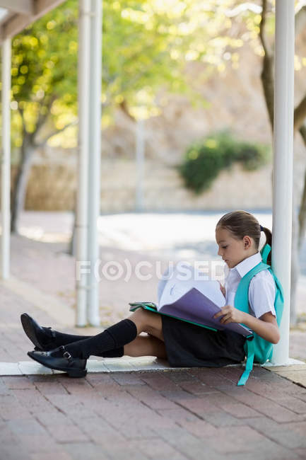 Schulmädchen im Flur liest Bücher — Stockfoto