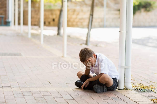 Trauriger Schüler sitzt allein im Flur — Stockfoto