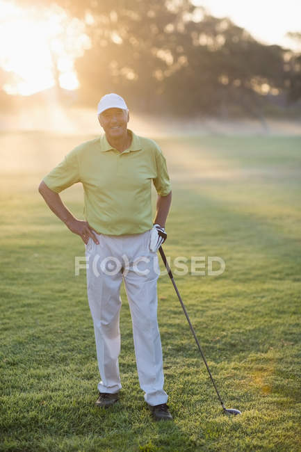 Golfista sorridente con mano sul fianco — Foto stock