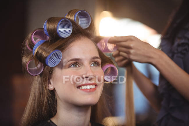 Female hairdresser styling customers hair — Stock Photo