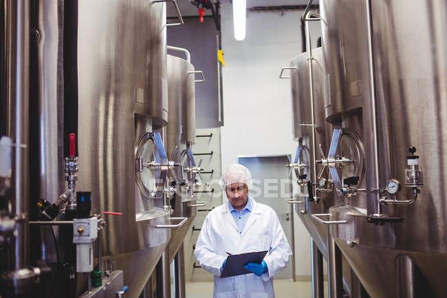 Produttore di scrittura in mezzo a serbatoi di stoccaggio presso birrificio — Foto stock