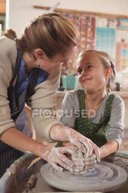 Femme potier interagissant avec fille — Photo de stock