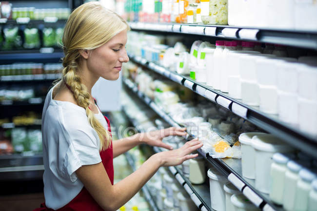 Personale che controlla i prodotti alimentari nello scaffale — Foto stock