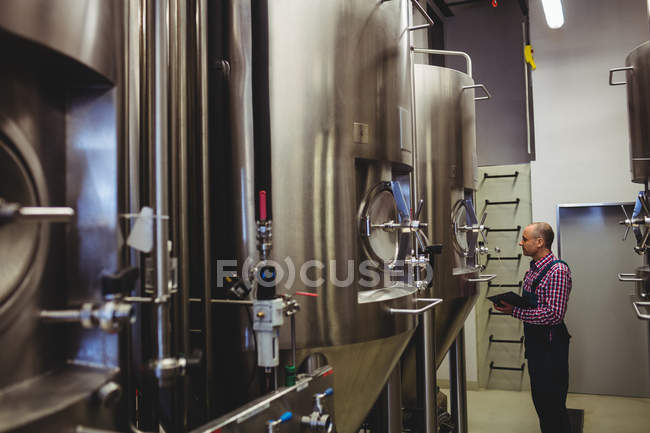 Proprietário examinando máquinas na cervejaria — Fotografia de Stock