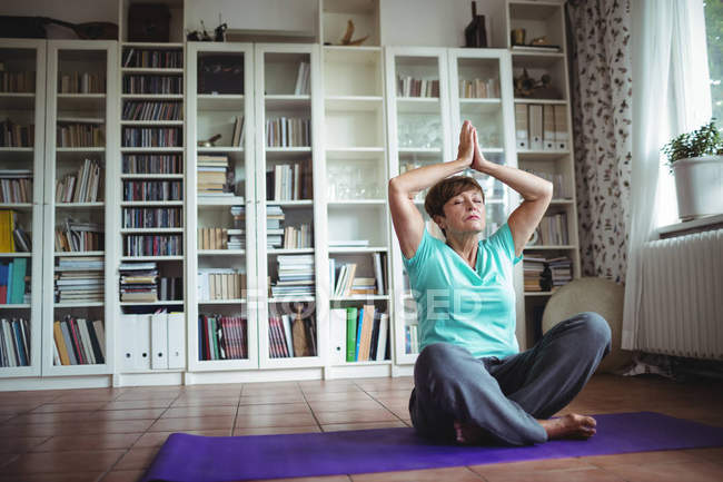 Старша жінка медитує в молитовній позиції — стокове фото