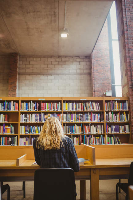 Mulher estudando na biblioteca — Fotografia de Stock