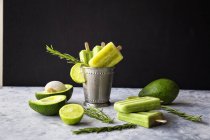 Avocado and lime popsicles placed on table and in vintage metal small bucket — Stock Photo