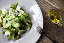 Вид зверху на м'ясний безкоштовний салат зі шпинатом у білій мисці на дерев'яному столі — стокове фото