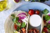 Placa de vista superior de tacos vegetarianos com molho na mesa de mármore — Fotografia de Stock
