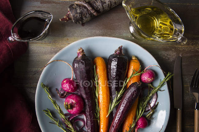 Carottes rôties et grillées avec radis et romarin dans une assiette — Photo de stock