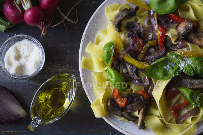 Вегетаріанська паста з грибами, овочами та травами на тарілці — стокове фото