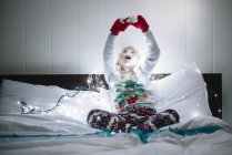 Niña en la cama esperando a Santa Claus - foto de stock