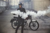 Motorbike woman in the street holding a smoke flare — Stock Photo