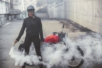Mujer moto en la calle sosteniendo una bengala de humo - foto de stock
