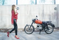 Motocicletta donna camminare accanto alla moto — Foto stock