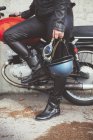 Casco y gafas en la mano de la mujer moto - foto de stock