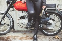 Helmet and goggles in the hand of the motorbike woman — Stock Photo