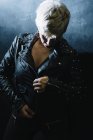 Портрет коротковолосой женщины, застегивающей кожаную куртку — стоковое фото