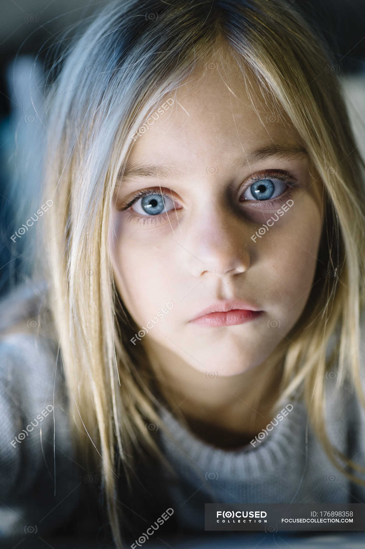 Beautiful blonde preteen girl with big blue eyes looking ...